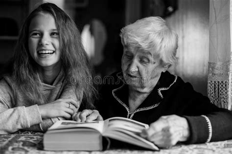 Grandmother An Old Woman With Granddaughter A Little Girl Reading A