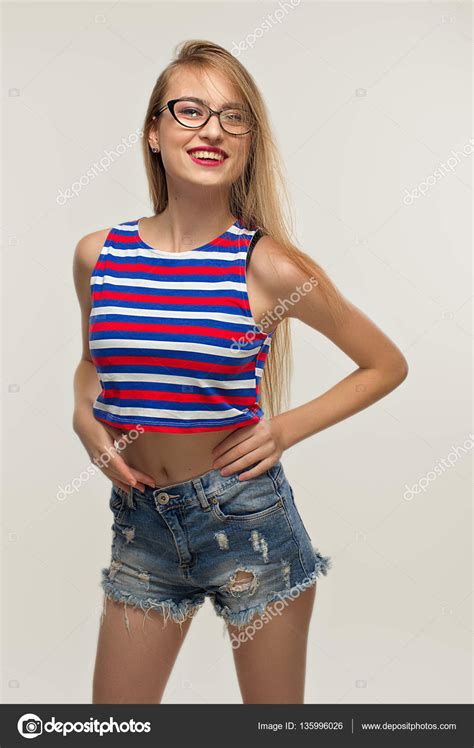 beautiful blonde girl in glasses and in striped top jeans shirt she is very serious female