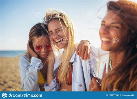 friends walking on the beach and laughing on a summer day enjoying vacation stock image image