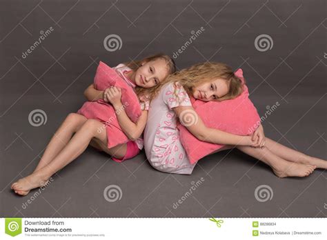 Beautiful Two Girls In Pink Pajamas Play Before Going To Bed Stock