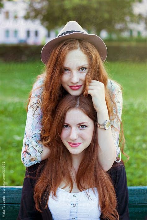 Two Beautiful Redheaded Sisters Looking In Camera On A Sunny Day By