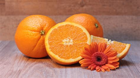 Sliced Orange Fruit Against Two Orange Fruits Hd Wallpaper Wallpaper
