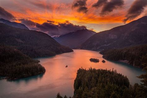 Aerial Photography Of Lake Viewing Mountain Under Orange Skies Photo