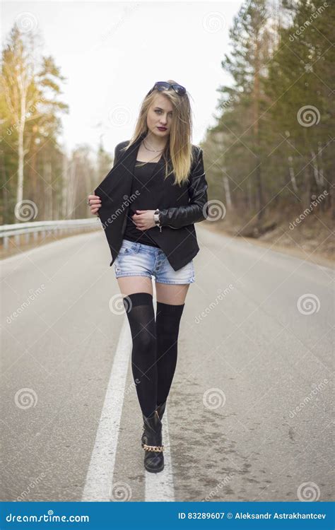 Beautiful Young Girl Walking Down The Road In The Forest Stock Image