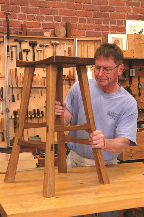 A Man Is Working On A Wooden Chair