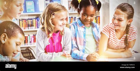 Kids Interacting With Each Other In Library Stock Photo Alamy
