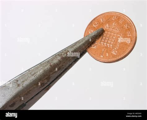 Penny Pinching A Penny Gripped By Pliers Stock Photo Alamy