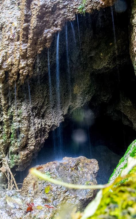 Water Flows Through Rocks In The Cave A Small Waterfall At The