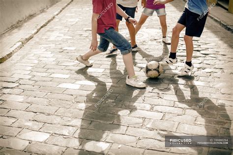 Niños Jugando Con Pelota De Fútbol En La Calle Adoquinada — Chicos