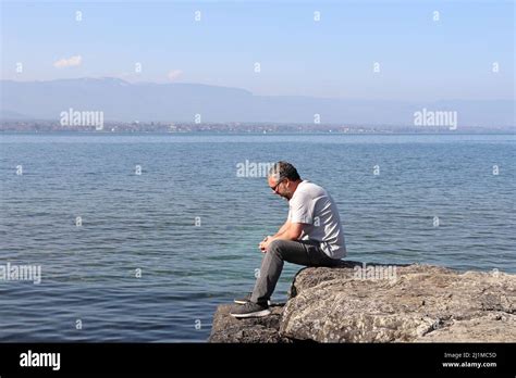 Male Sitting On A Rock Looking Back Hi Res Stock Photography And Images