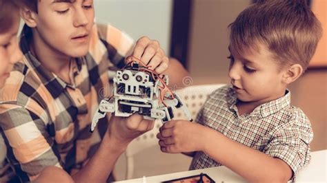 Tiener En Twee Jongens Die Robot Thuis Construeren Stock Foto Image