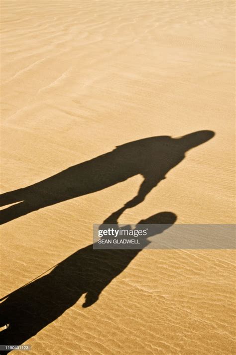 Mother Child Shadow Holding Hands On Sand High Res Stock Photo Getty