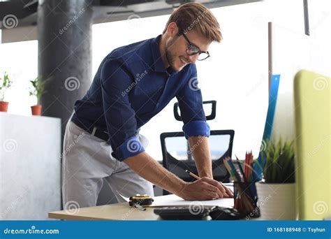 Shot Of A Handsome Male Architect Working On A Design In His Office