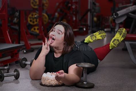 Overweight Girl Does Not Want To Lose Weight Lies On The Floor Of The Gym With A Cake Stock