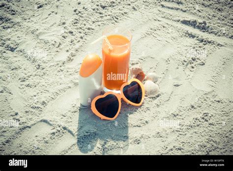 Carrot Juice Sunglasses And Sun Lotion On Sand At Beach Concept Of Prevention Of Vitamin A