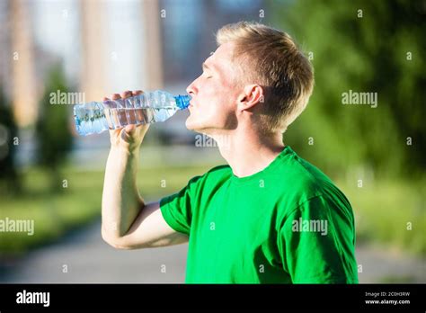 Tired Man Drinking Water From A Plastic Bottle After Fitness Stock