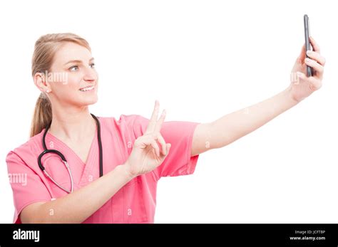 Nurse Wearing Scrubs Taking Selfie With Smartphone Showing Peace And Smiling Isolated On White