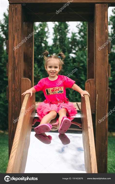 Cute Little Girl Descends Wooden Children Slide — Stock Photo © Photo