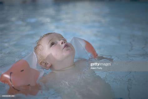 Boy Wearing Armbands Floating In Swimming Pool High Res Stock Photo