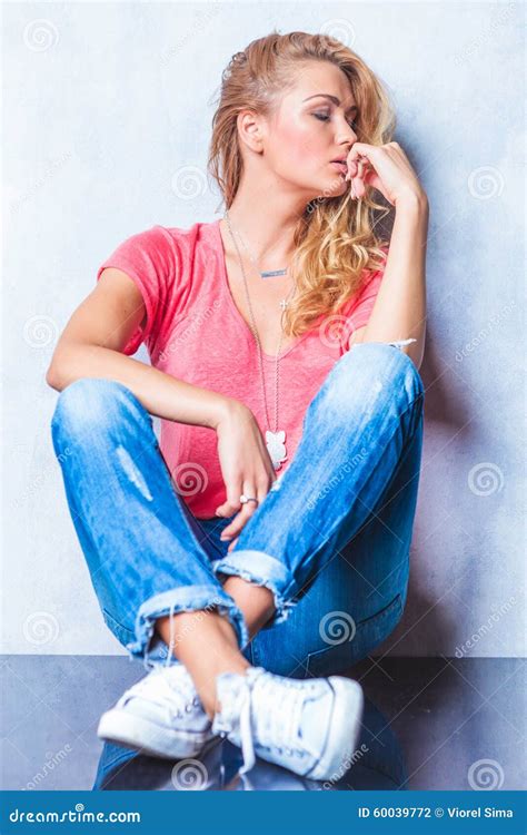 Girl Sitting On The Floor With Her Legs Crossed And Looking Away Stock