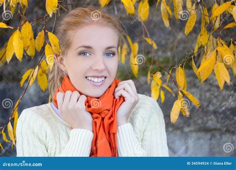 Portrait Of Beautiful Woman In White Sweater Posing Against Stone Wall