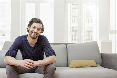 Smiling Man Sitting On Sofa Stock Photo
