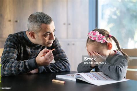 Angry Father Scolding His Daughter While She Is Doing Homework Stock
