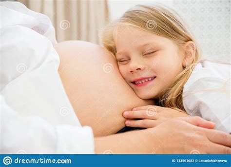 Happy Smiling Pregnant Mother Hugging With Her Daughter At Home Stock Photo Image Of