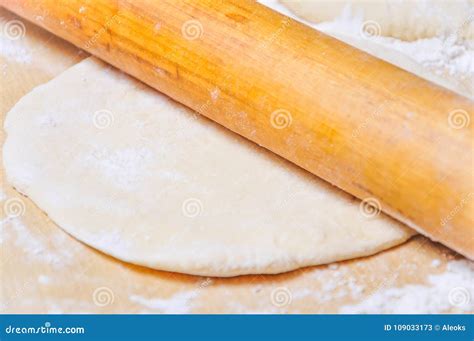 Rolled Wheat Dough And Rolling Pin On A Wooden Table Stock Image