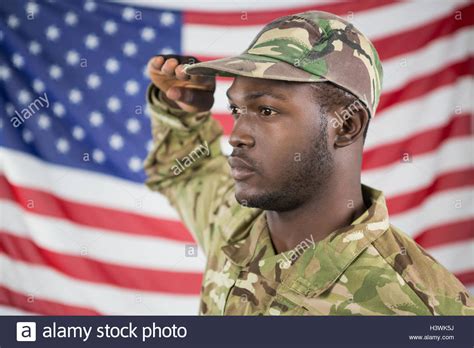 Soldier Saluting Against American Flag Stock Photo Alamy