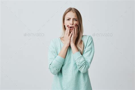 Shocked Stunned Blonde European Woman With Opened Mouth Holding Hands