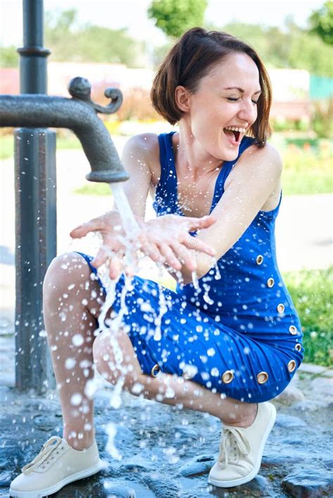 Young Girl Playing With Water Squirt And Making Splashes Stock Image