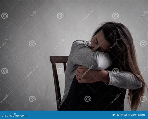 Depressed Broken Hearted Woman Sitting Alone In Dark Room Stock Photo