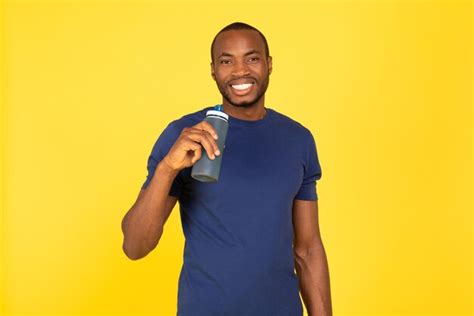 Premium Photo Sporty Black Man Drinking Water Holding Bottle Over