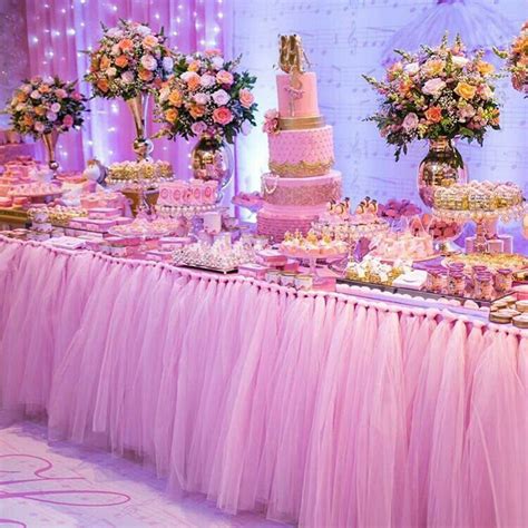 A Table Topped With Lots Of Pink And Gold Desserts Next To Tall Vases