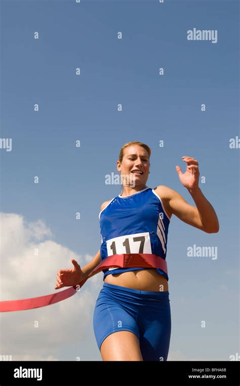 Female Track Athlete Crossing Finishing Line Stock Photo Alamy