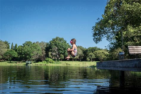 girl doing cannonball trick off dock by stocksy contributor alison winterroth stocksy