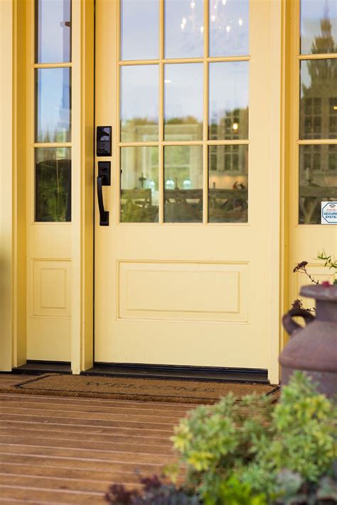 The Front Door To A Yellow Building With Two Telephones On Its Side