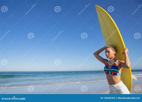 Beautiful Woman In Bikini Carrying The Surfboard On Her Head At Beach In The Sunshine Stock