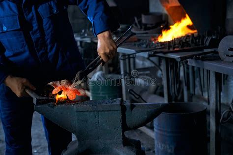 Blacksmith Heating Metal With Special Tools In Smithy Stock Photo