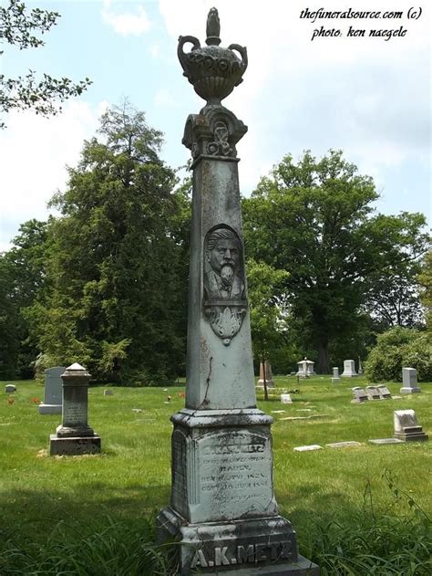 An Old Grave With A Bust On It In The Middle Of A Grassy Cemetery Area