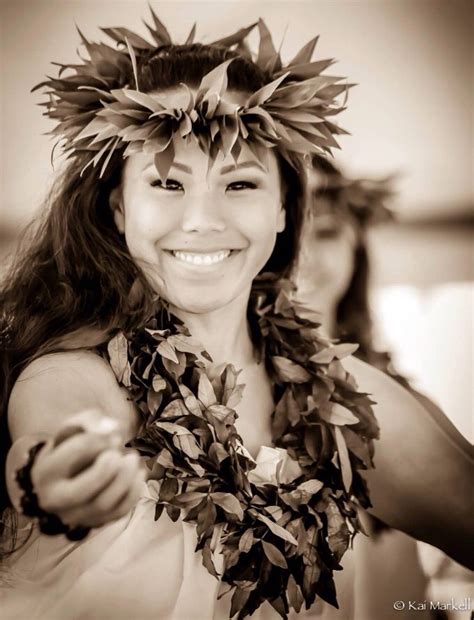 hula dancer holding ili ili river rocks used like castanets wearing ti leaf lei on her head
