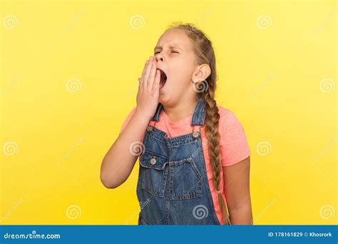 Portrait Of Exhausted Child Drowsy Little Girl With Braid In Denim