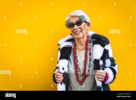 happy and playful senior woman having fun portrait of a beautiful lady above 70 years old with