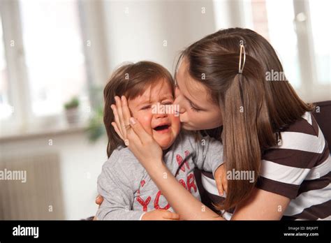 Teenage Girl Kissing Crying Baby Boy Stock Photo Alamy