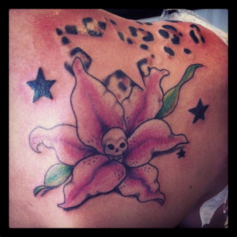 A Woman With A Skull And Flower Tattoo On Her Back