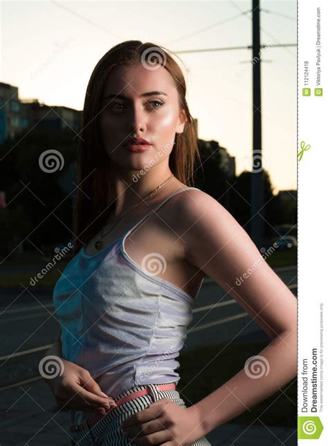 Adorable Young Brunette Woman Posing In The Shadows At The Street Stock
