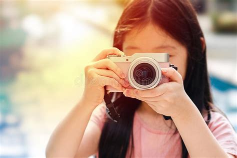 Asian Child Holding Camera Taking Photo Illustrating Travelling Stock