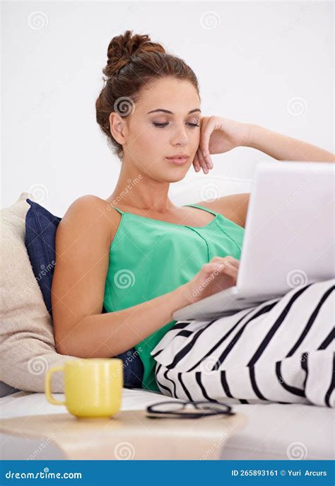 Enjoying Some Down Time With Her Laptop Beautiful Young Woman Relaxing On The Sofa With Her