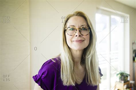 Portrait Of Smiling Blond Mature Woman Wearing Glasses
